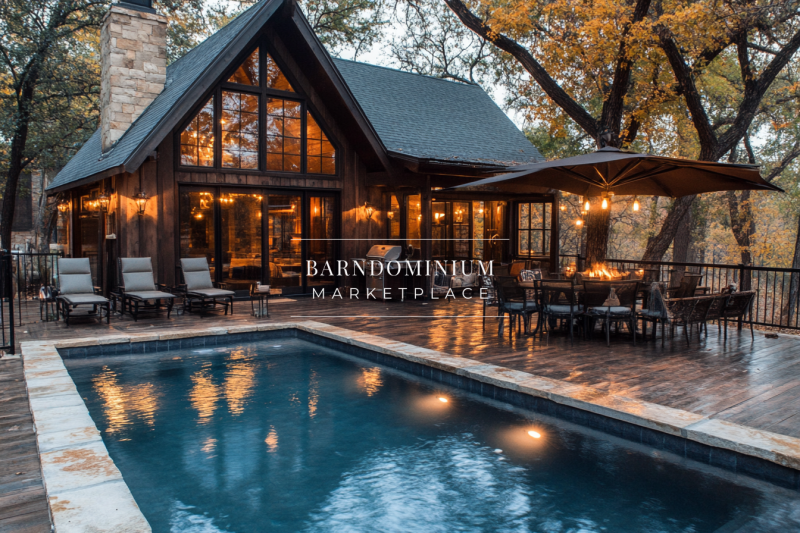 A stunning rustic barndominium with floor-to-ceiling windows, warm lighting, and a private poolside retreat surrounded by autumn foliage.