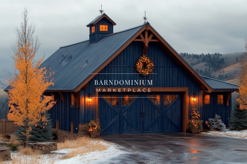 A stunning navy-blue barndominium with warm golden lights, nestled in a peaceful mountain setting with autumn foliage and light snowfall.