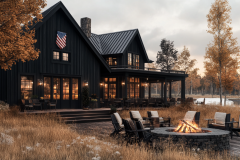 Modern farmhouse-style home with a dark exterior, warm interior lighting, and a cozy firepit seating area.