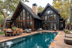 A stunning black barndominium with rustic wood accents, large glass windows, and a shimmering pool, creating a perfect blend of modern and cozy living.