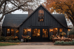 A stunning black barndominium with warm ambient lighting, rustic charm, and a cozy autumn vibe.
