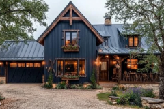 Charming black barndominium with rustic wood accents, warm lighting, and a cozy front porch.