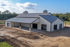 Modern white barndominium exterior with black trim, large covered porch, and spacious open layout.