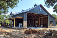 Barndominium under construction featuring a metal exterior, open framework, and rustic design elements.