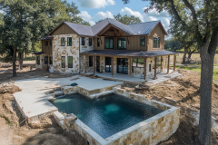 Rustic barndominium with stone and wood exterior, featuring a luxurious backyard pool and spacious outdoor living area.
