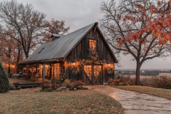 Charming rustic barndominium exterior with warm string lights, weathered wood siding, and a peaceful countryside setting.