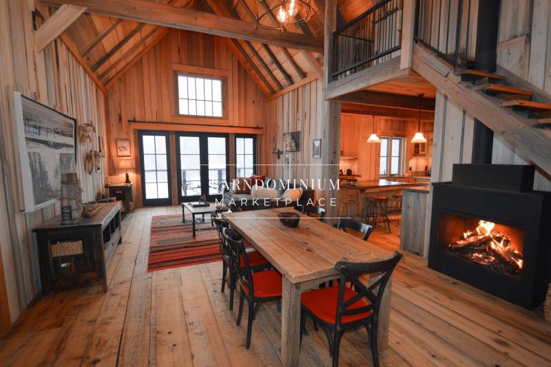 Warm and inviting barndominium interior with high vaulted ceilings, natural wood finishes, and a cozy fireplace.