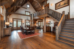 Spacious barndominium interior with exposed wood beams, an open floor plan, and a rustic farmhouse aesthetic.