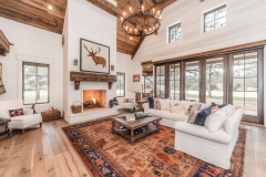 Bright and airy barndominium living room with a vaulted ceiling, cozy fireplace, and rustic farmhouse decor.