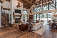 Rustic yet modern barndominium interior featuring vaulted ceilings, large windows, and cozy farmhouse decor.