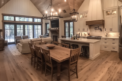 Modern farmhouse-style kitchen and dining area with vaulted ceilings, natural wood accents, and a cozy open-concept layout.