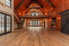 Stunning barndominium interior featuring soaring vaulted ceilings, rich wood accents, a cozy fireplace, and a spacious open-concept loft design.