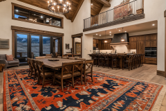 Elegant barndominium dining area with vaulted ceilings, a grand chandelier, and a spacious open-concept kitchen.