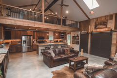 Modern rustic barndominium interior with an open-concept living space, vaulted ceilings, and a stylish loft.