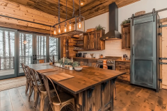 A stunning rustic barndominium kitchen with warm wood tones, industrial lighting, and a spacious farmhouse-style island for dining and entertaining.