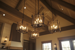 A vaulted barndominium kitchen ceiling showcasing elegant lantern-style chandeliers, blending rustic charm with modern lighting design.