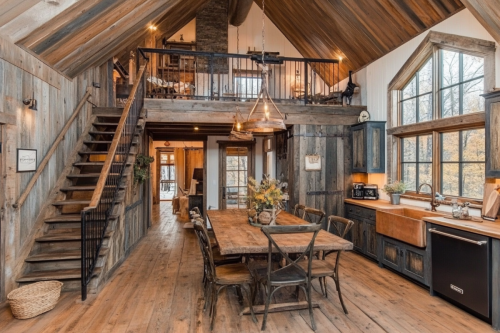 A beautifully designed rustic barndominium featuring an open-concept kitchen, lofted living space, vaulted ceilings, and warm wood accents.