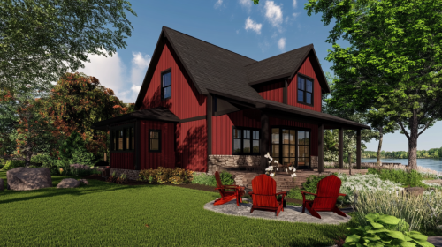 A charming red lakehouse barndominium with a covered porch, stone accents, and Adirondack chairs arranged around a fire pit, overlooking a peaceful waterfront setting.